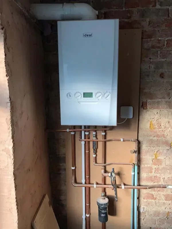 New boiler fitted on a brick wall with neat copper pipework