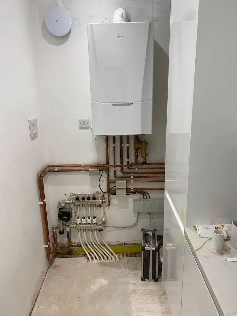 New boiler with copper pipework and a heating manifold below it